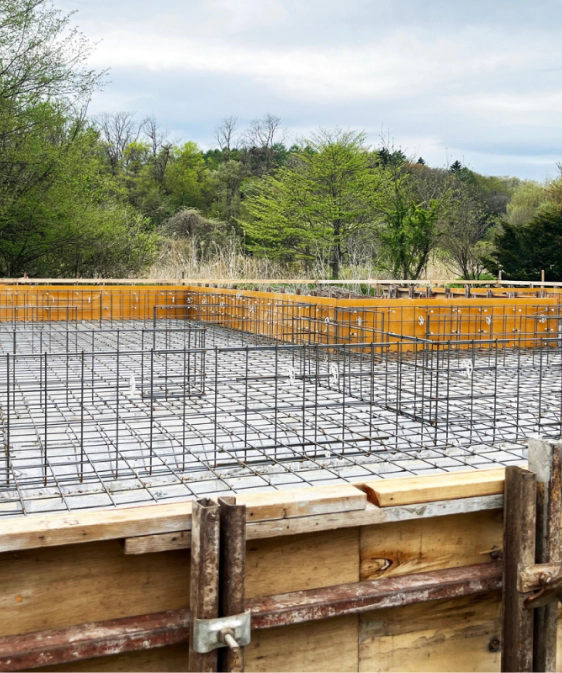 Rebar mat tied inside footing forms before a concrete pour
